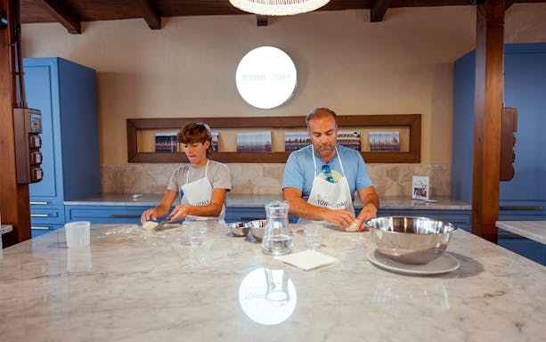 Participants kneading dough during a cooking class in Palermo.