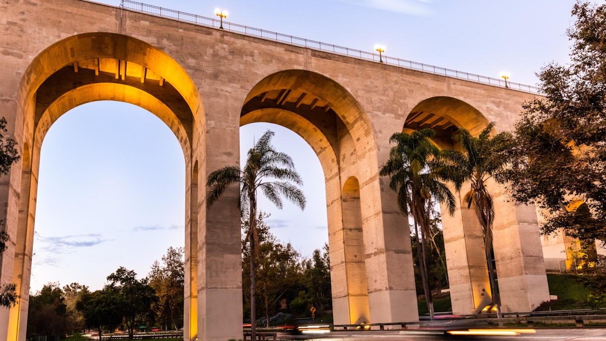 Cabrillo Bridge arches with palm trees in San Diego at dusk.