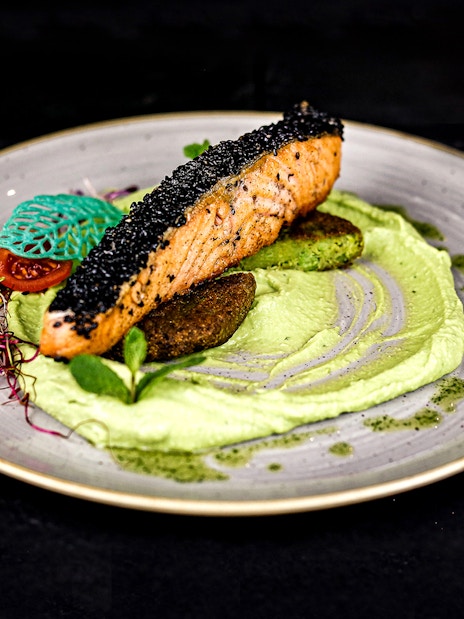 Grilled salmon with black sesame on pea puree, served on a Christmas cruise in Budapest.