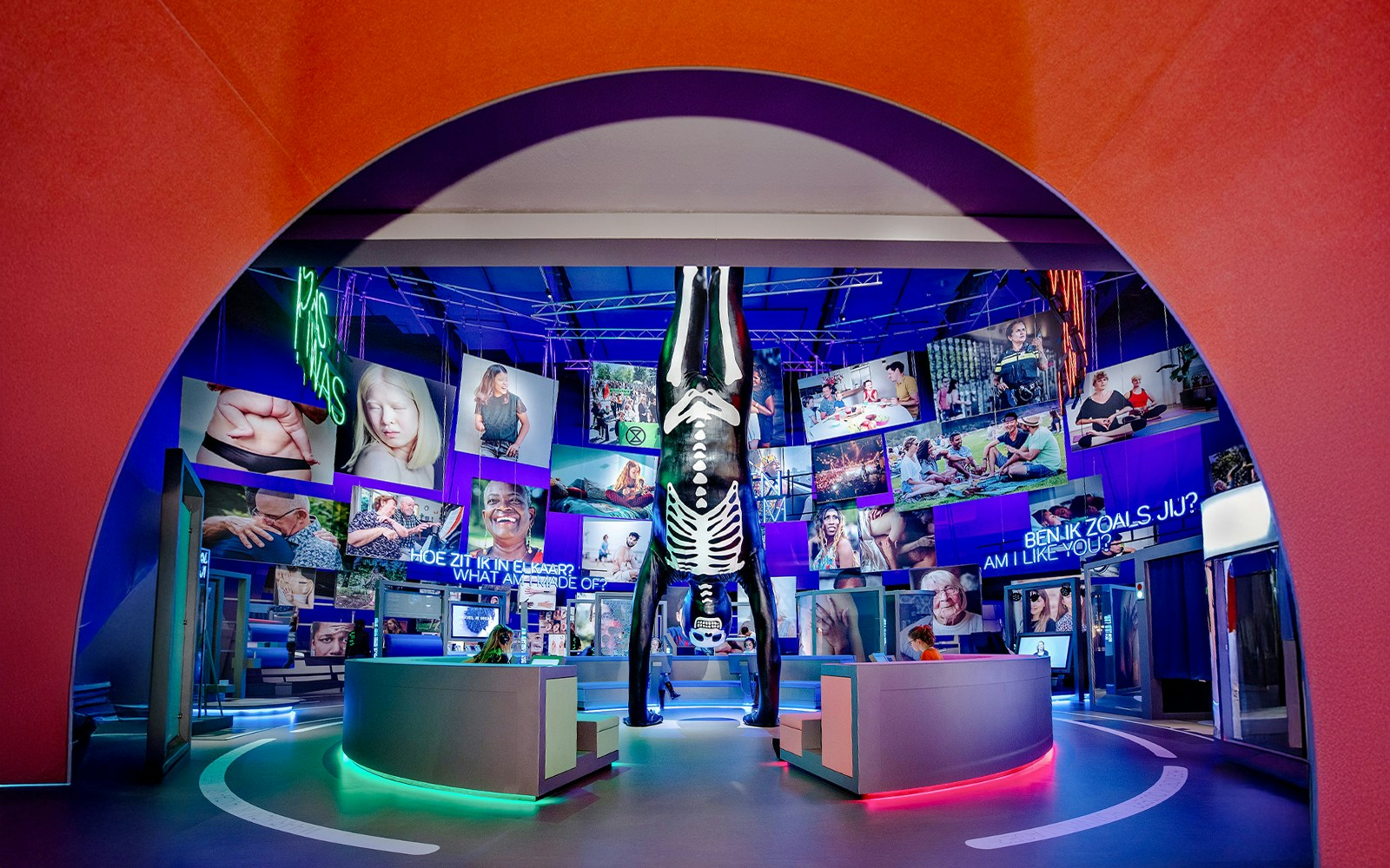 Visitors engaging with human biology exhibit at NEMO Science Museum, Amsterdam, using interactive models and screens.
