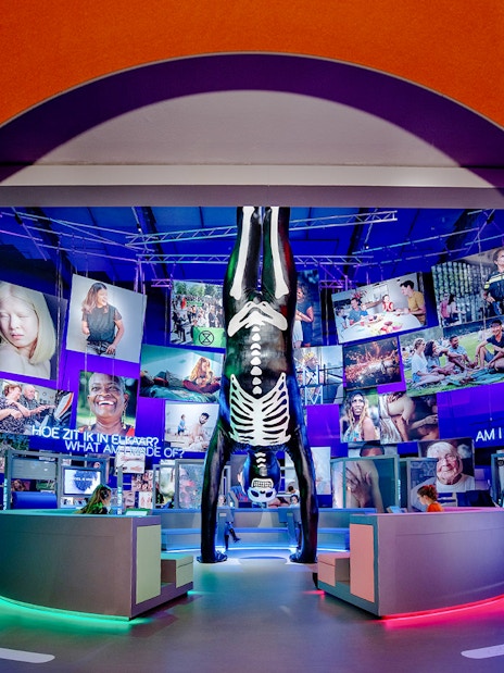 Visitors engaging with human biology exhibit, interacting with models and digital screens.