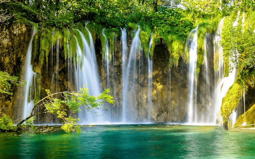 Waterfalls cascading into turquoise water at Plitvice Lakes, Croatia.