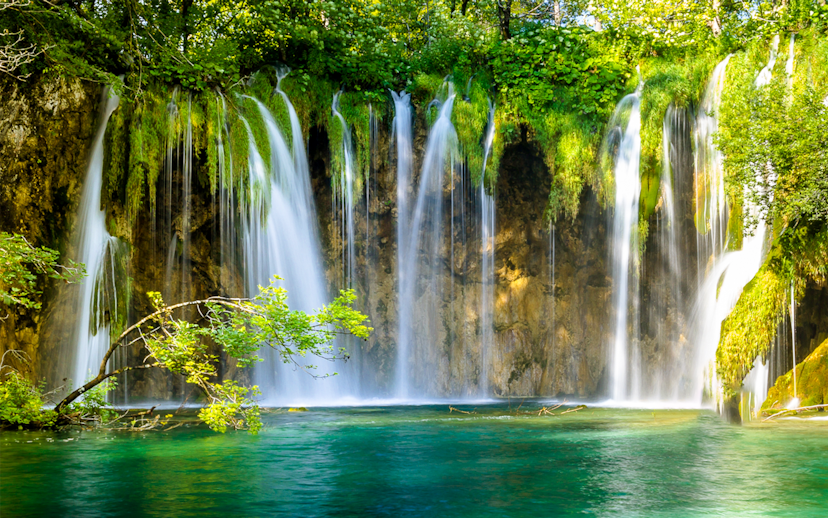 Waterfalls cascading into turquoise water at Plitvice Lakes, Croatia.