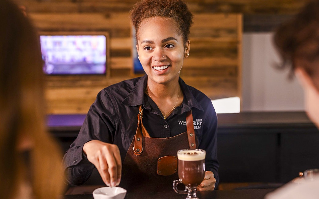 Barista preparing Irish coffee at the Irish Whiskey Museum masterclass.