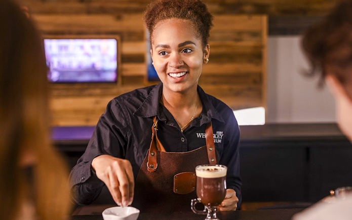 Barista preparing Irish coffee at the Irish Whiskey Museum masterclass.