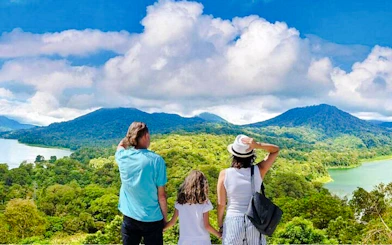Family overlooking Bali's twin lakes and jungle during a trekking tour.