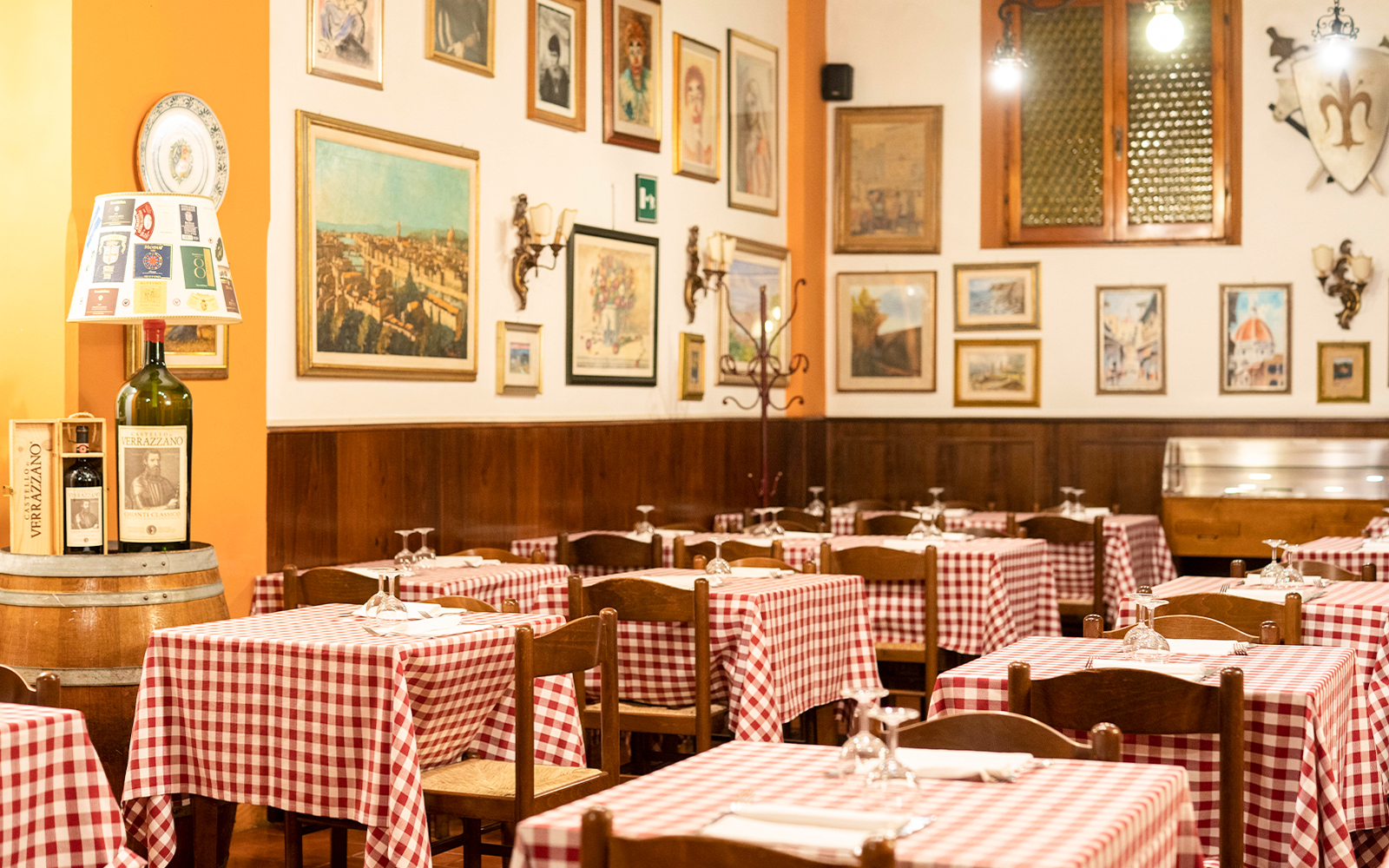 Tuscan restaurant with checkered tablecloths in Florence, Italy, set for dinner.