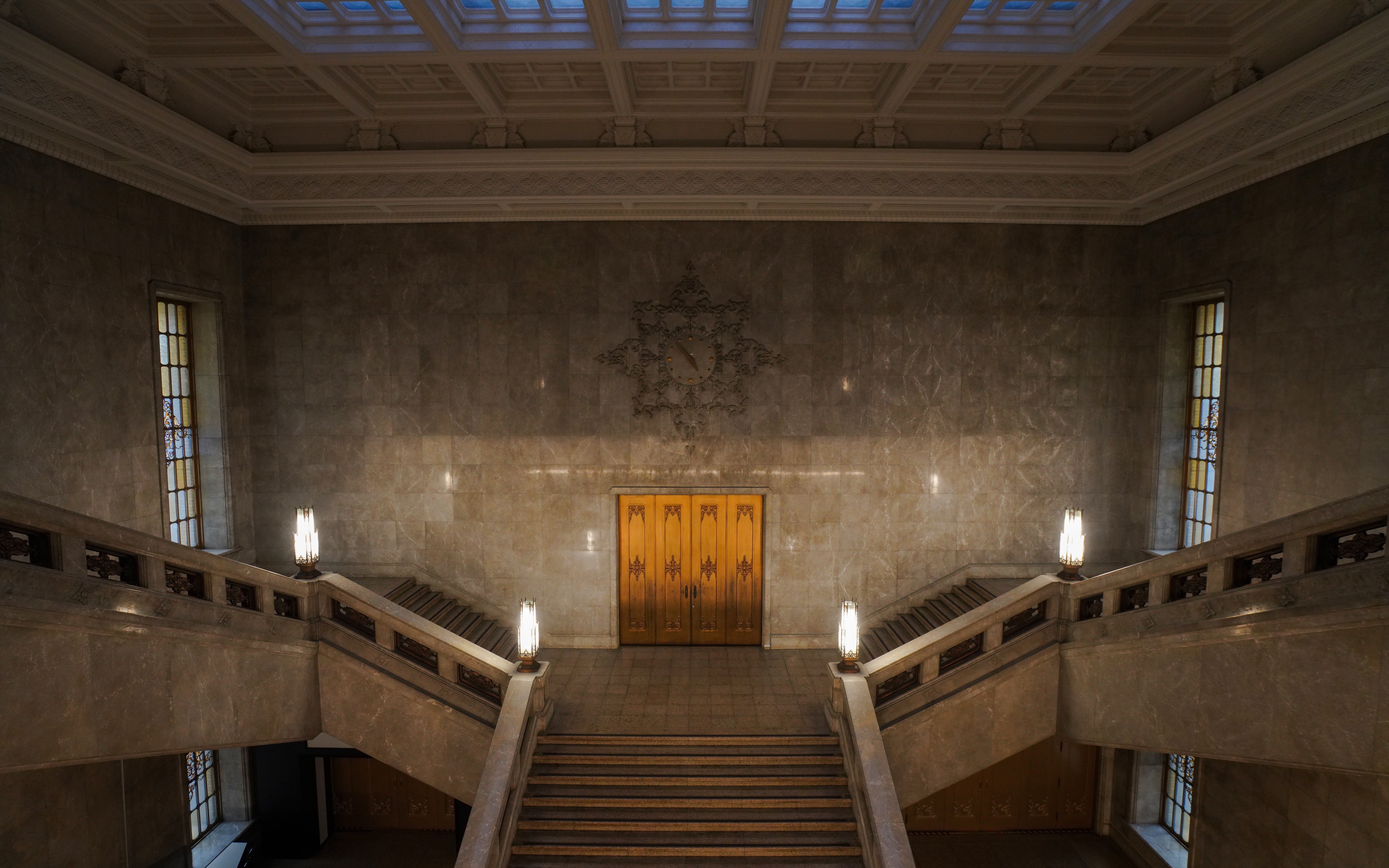 Grand staircase inside the Honkan of the Tokyo National Museum with ornate lighting.
