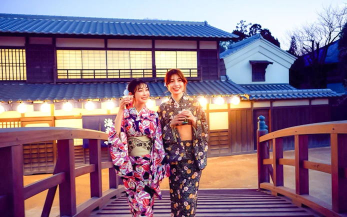 Two people in kimonos walking on a bridge at TOEI Kyoto Studio Park.
