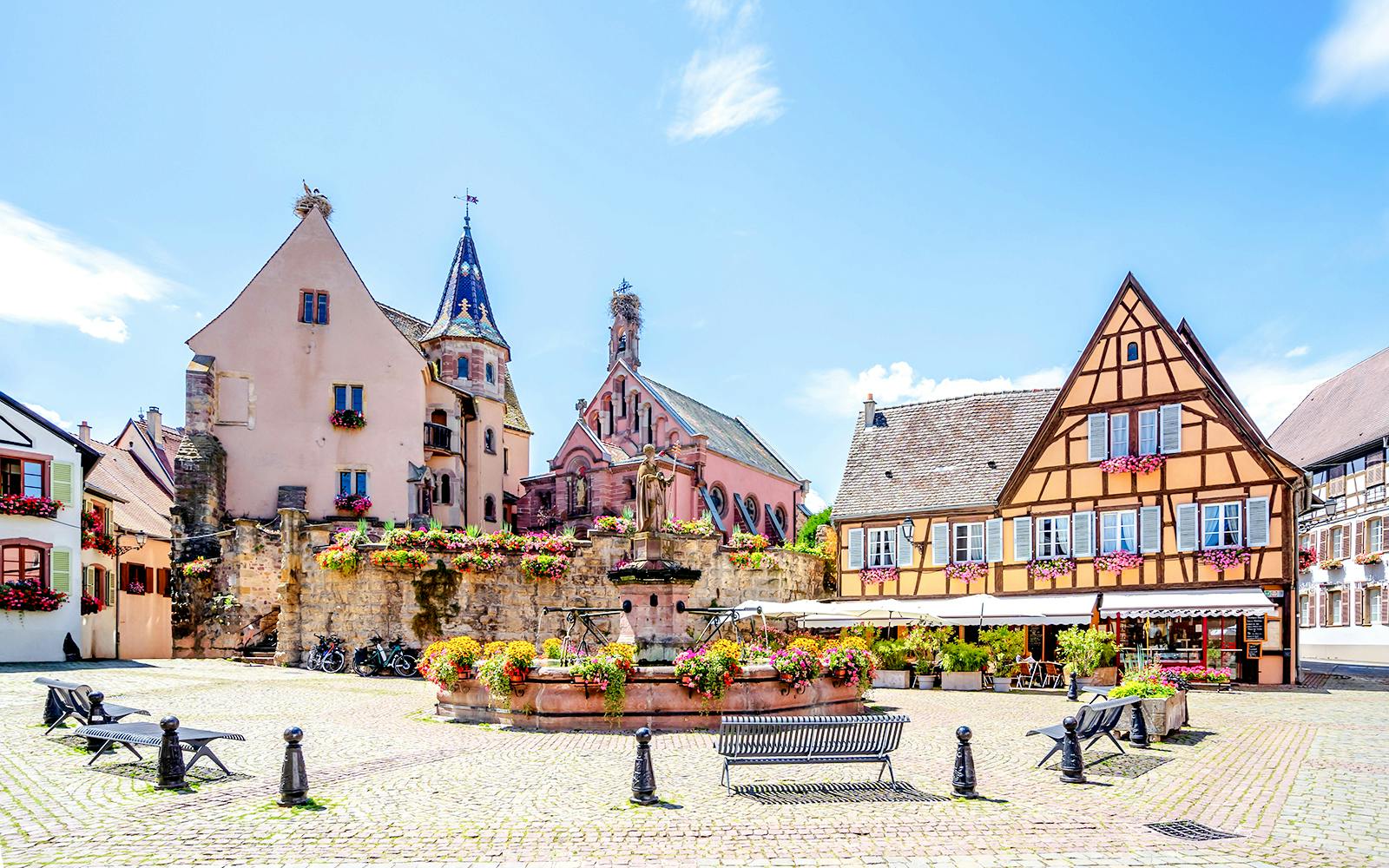 Colorful half-timbered houses and a fountain in Eguisheim, France.