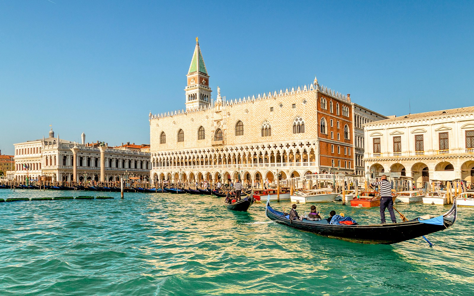 Gondola ride on Venice canal near Doge's Palace in the evening.