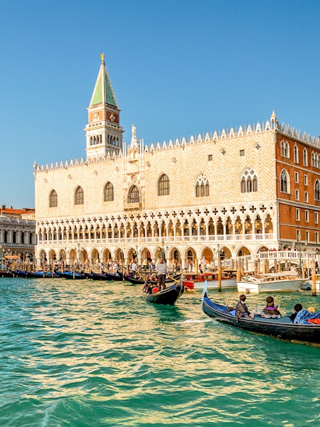 Gondola ride on Venice canal near Doge's Palace in the evening.