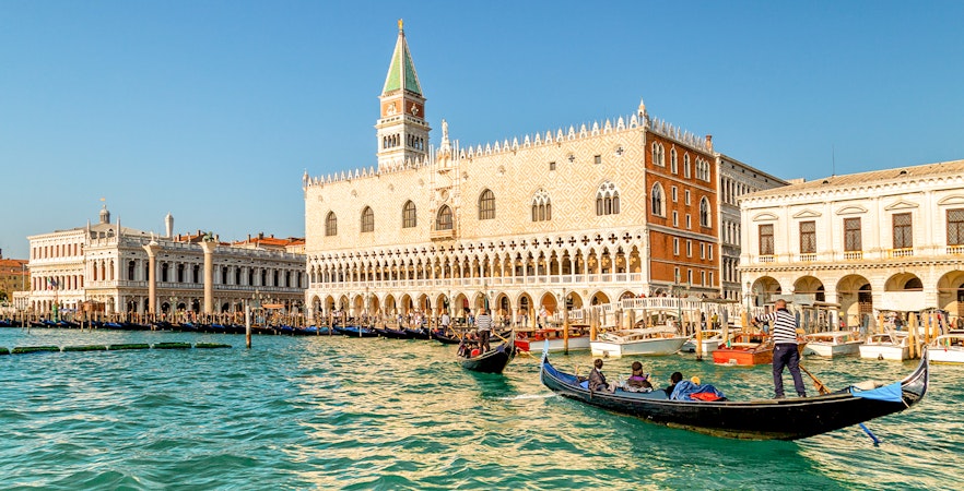 Gondola ride on Venice canal near Doge's Palace in the evening.