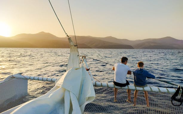 Tourists on a cruise boat at sunset in Lanzarote, watching for whales and dolphins.