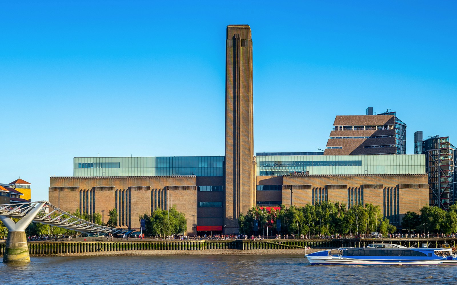Tate Modern exterior with river view and Millennium Bridge, London.