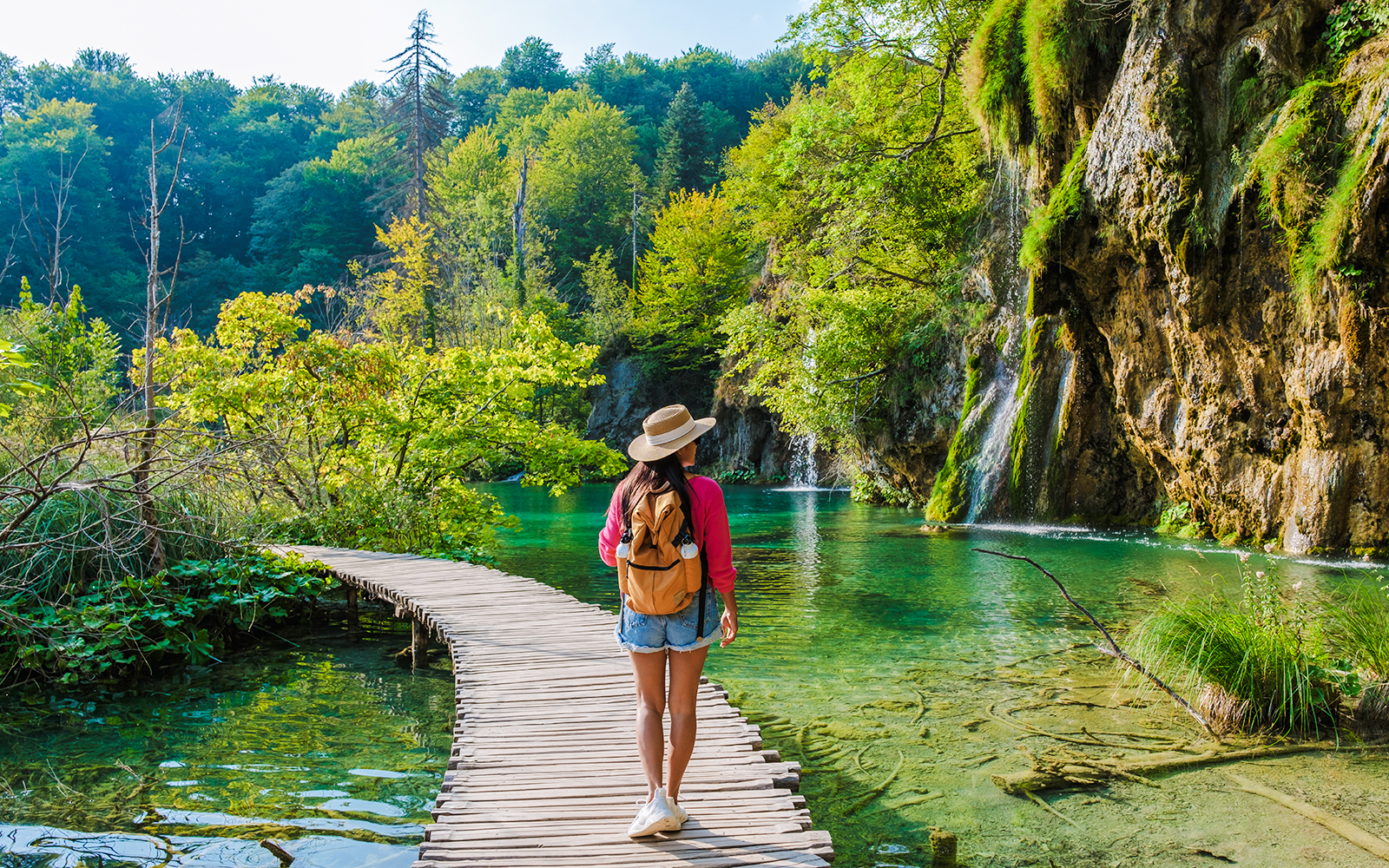 Guest walking on wooden path by waterfalls at Plitvice Lakes, Croatia.