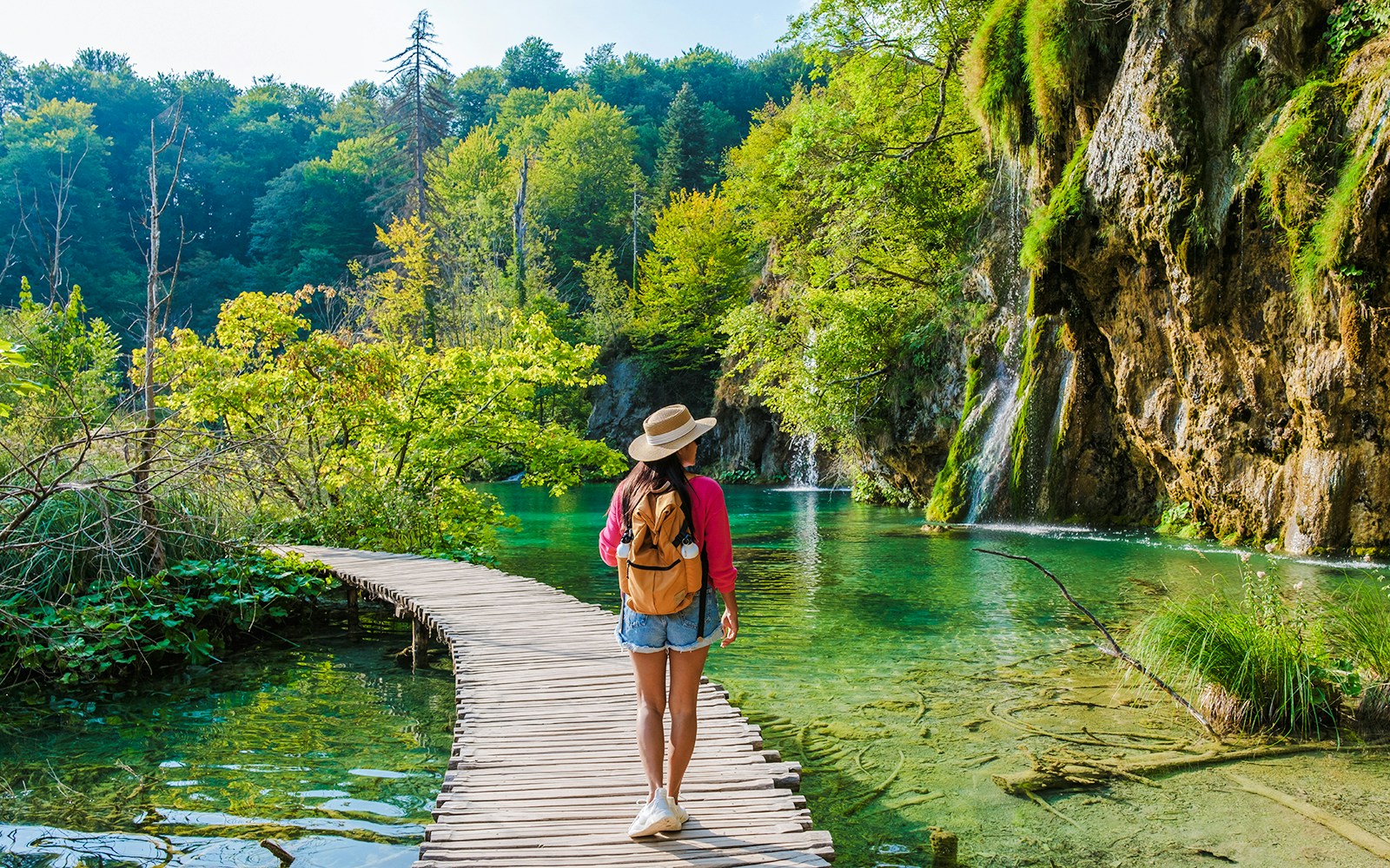 Guest walking on wooden path by waterfalls at Plitvice Lakes, Croatia.
