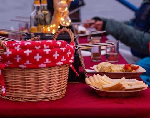 River rafting tour in Interlaken with raclette dinner setup on a table.