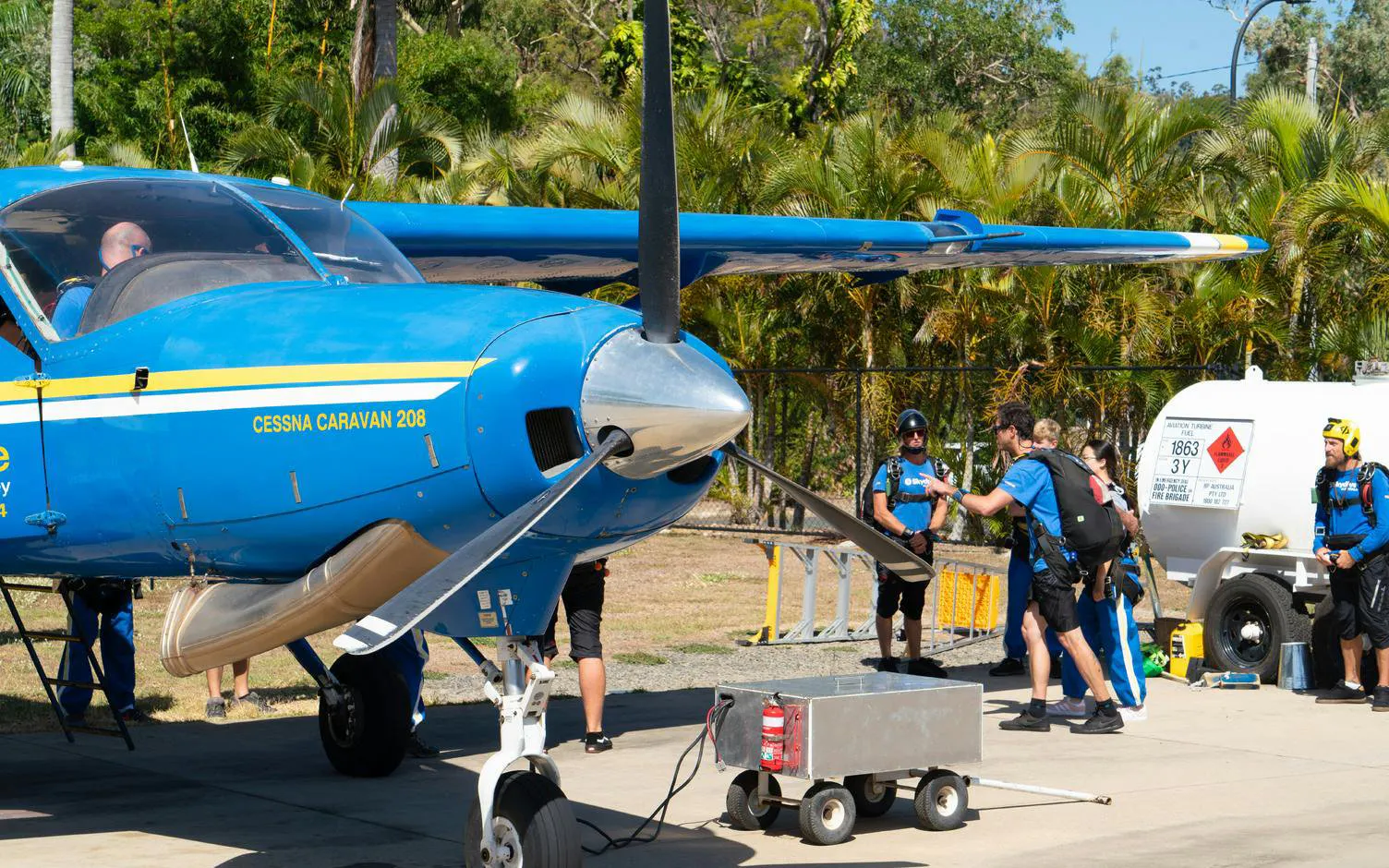 Skydivers preparing near a Cessna Caravan 208 at Airlie Beach for tandem skydive.