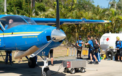 Skydivers preparing near a Cessna Caravan 208 at Airlie Beach for tandem skydive.