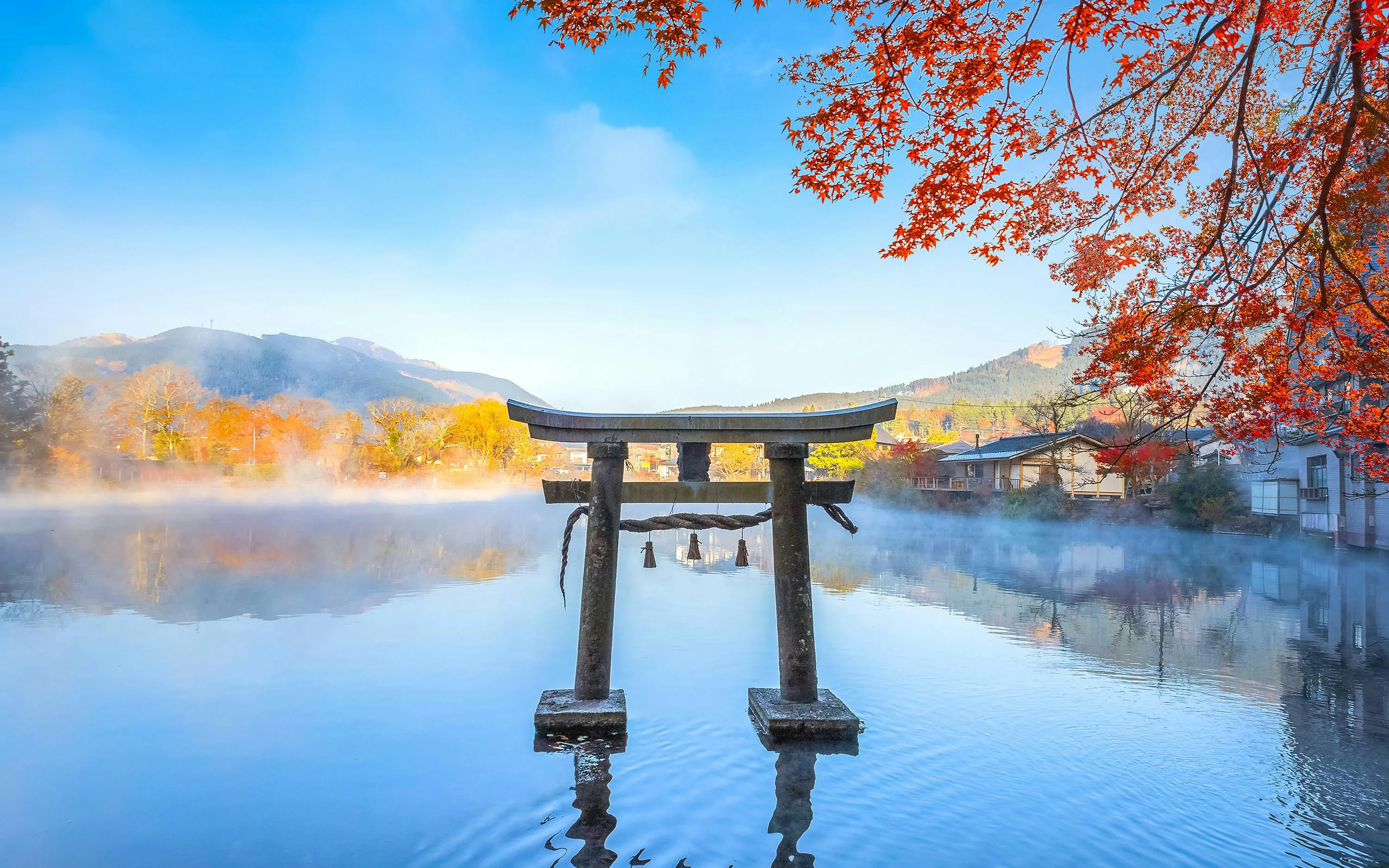 Torii gate at Lake Kinrin with autumn leaves, Yufuin, Japan.