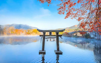 Torii gate at Lake Kinrin with autumn leaves, Yufuin, Japan.
