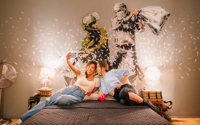 Visitors taking a selfie in front of Banksy artwork at Banksy Museum Barcelona.