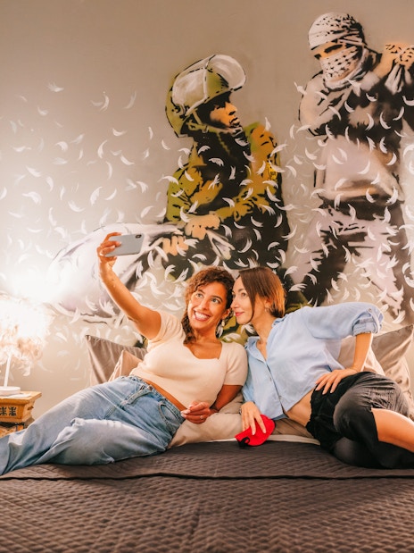Visitors taking a selfie in front of Banksy artwork at Banksy Museum Barcelona.