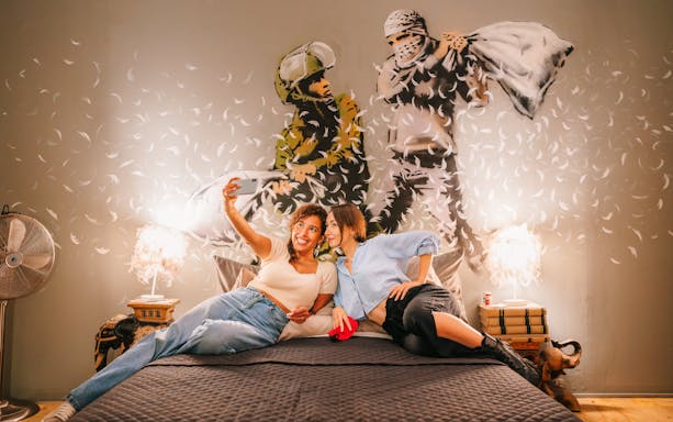 Visitors taking a selfie in front of Banksy artwork at Banksy Museum Barcelona.