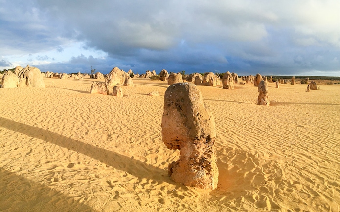 Pinnacles Desert limestone formations under a cloudy sky in Nambung National Park, Australia.