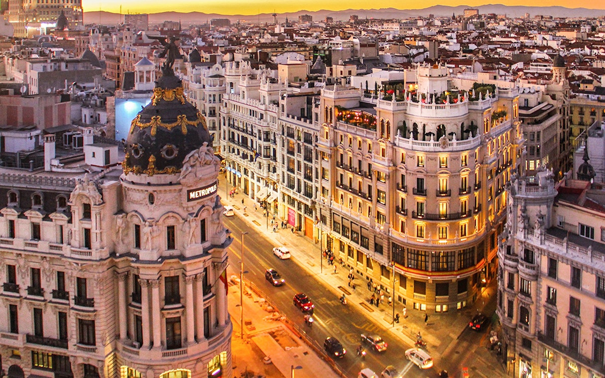 Aerial view of Gran Vía in Madrid at sunset, featuring the Metropolis Building.