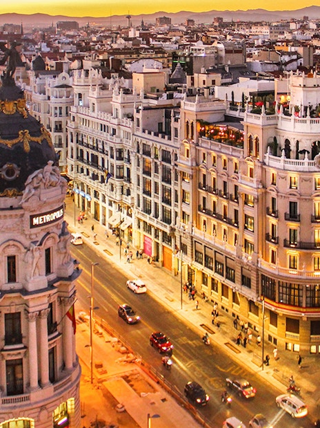Aerial view of Gran Vía in Madrid at sunset, featuring the Metropolis Building.