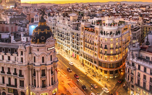 Aerial view of Gran Vía in Madrid at sunset, featuring the Metropolis Building.