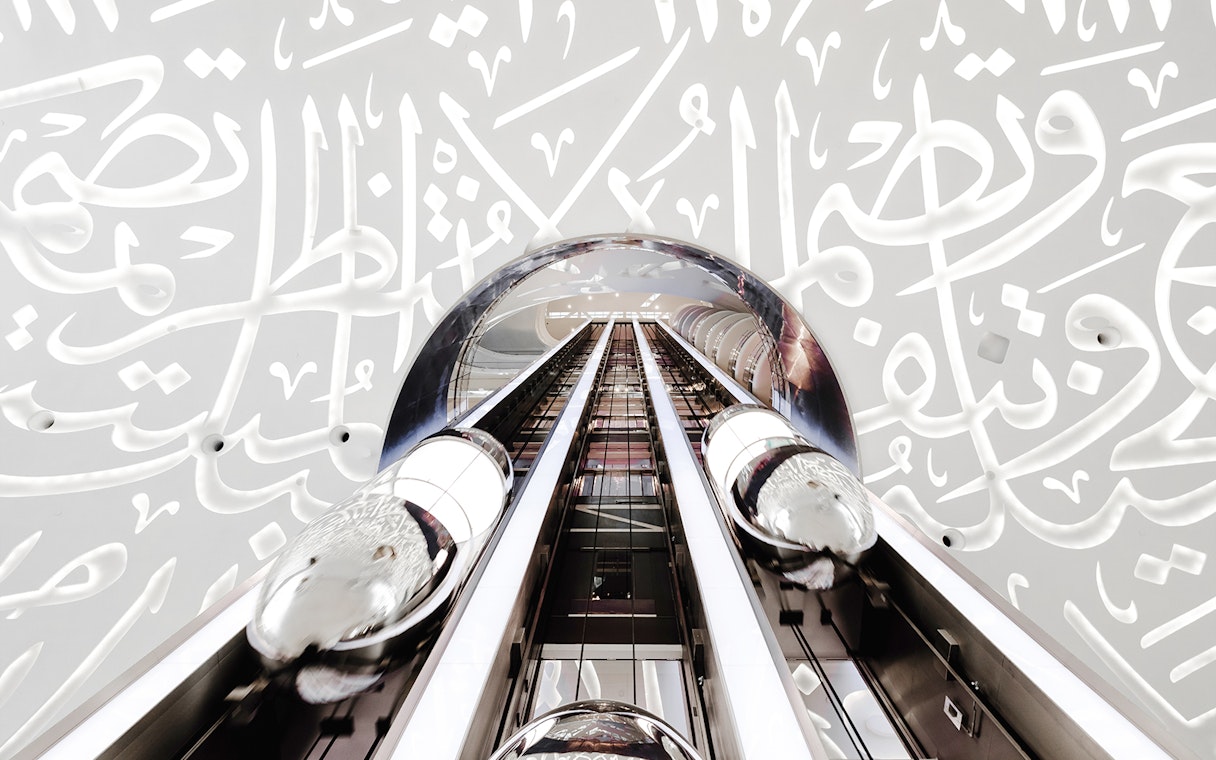 Futuristic elevator inside Museum of the Future, Dubai, with Arabic calligraphy walls.
