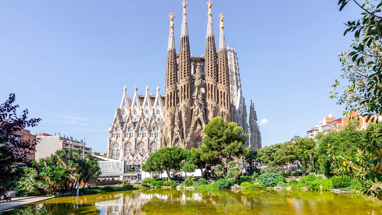 Sagrada Familia Cathedral interior with tourists exploring the intricate architecture, Barcelona.