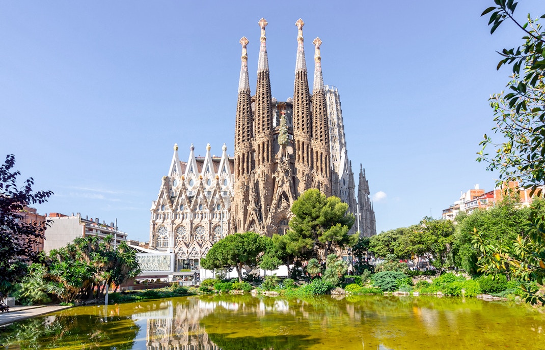 Sagrada Familia Cathedral interior with tourists exploring the intricate architecture, Barcelona.