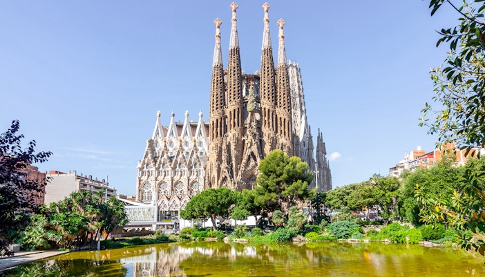 Sagrada Familia Cathedral exterior with tourists exploring the intricate architecture, Barcelona.
