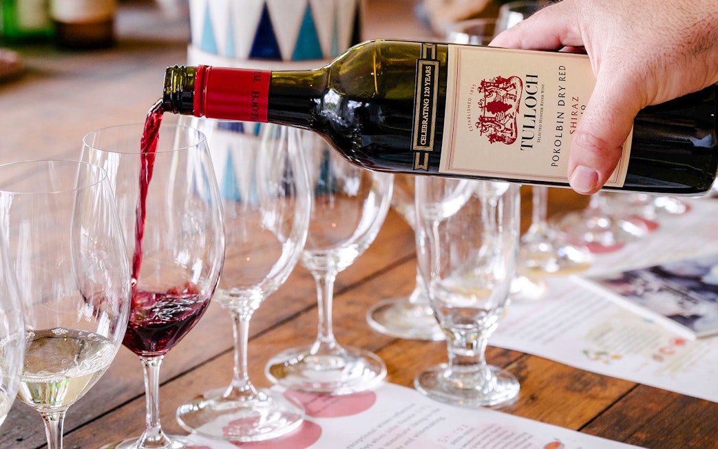 Pouring Tulloch red wine into glasses at Hunter Heroes tasting experience.