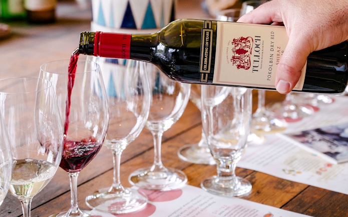 Pouring Tulloch red wine into glasses at Hunter Heroes tasting experience.
