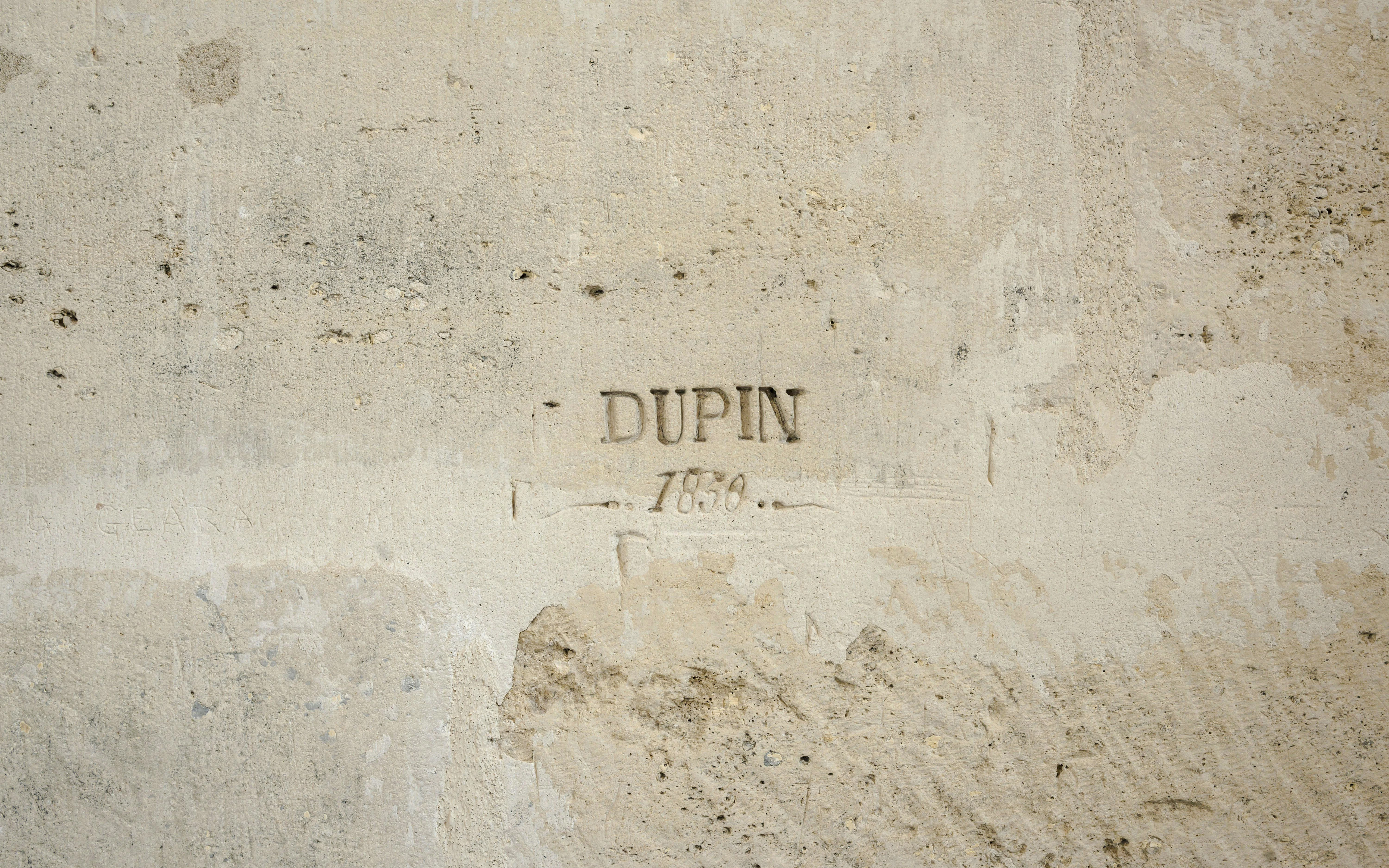 Carved inscription "Dupin 1750" on a wall at Château de Vincennes Prison.