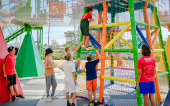 Children climbing colorful rope structure at Ko Fun Kids Rope Park, Phuket.