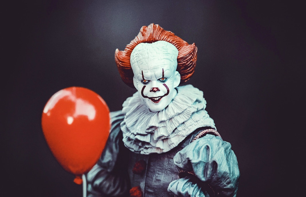 Wax figure of IT clown holding a red balloon at Madame Tussauds, NYC.