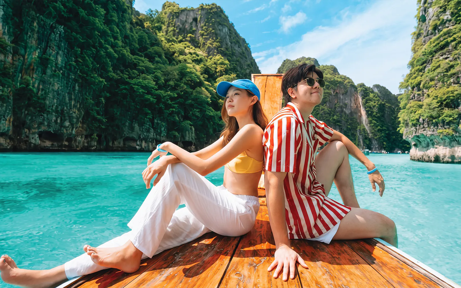 Tourists on a speedboat near Phi Phi Island's limestone cliffs, Phuket.