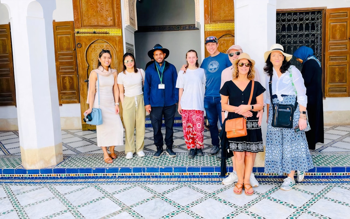 Group with guide at Bahia Palace courtyard, Marrakech, Morocco.