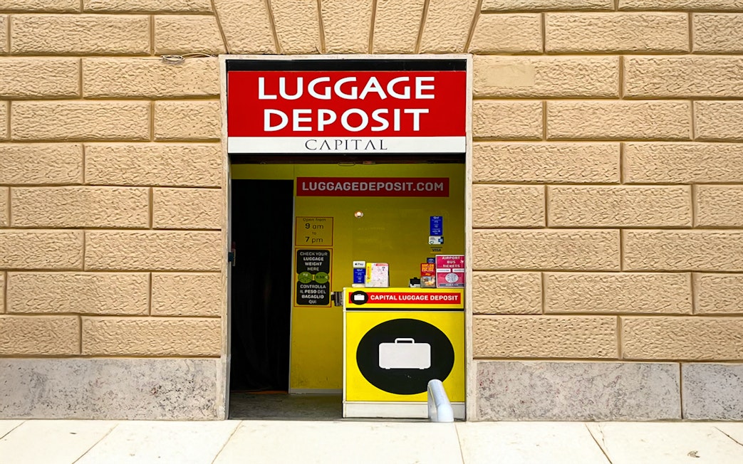 Luggage deposit service entrance in Rome with signage and operating hours.