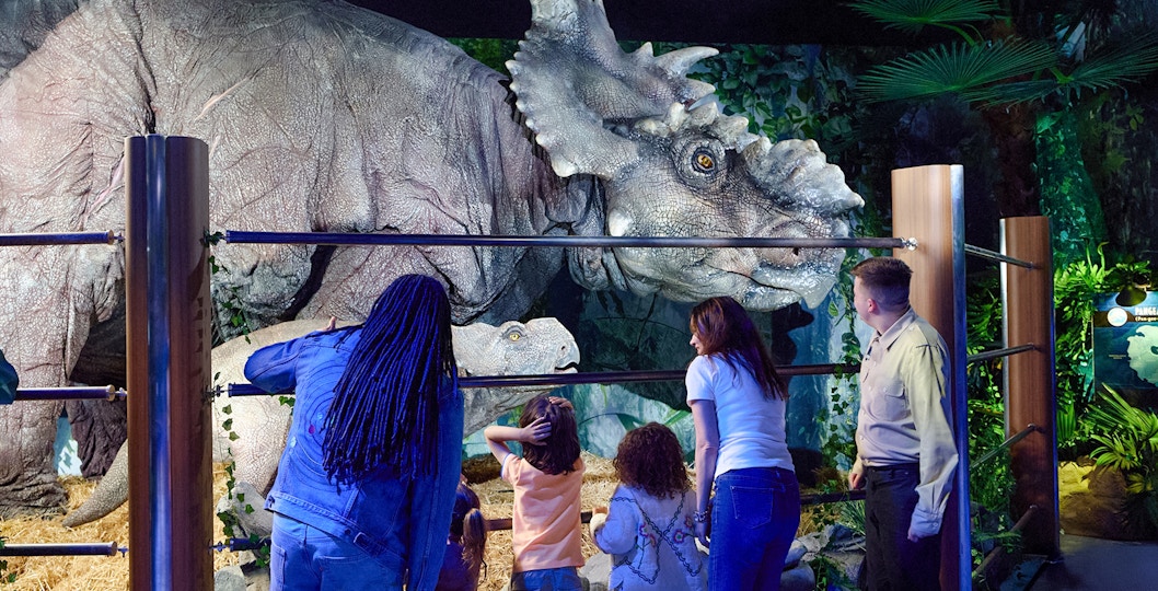 visitors observing dinosaurs at jurassic world experience london