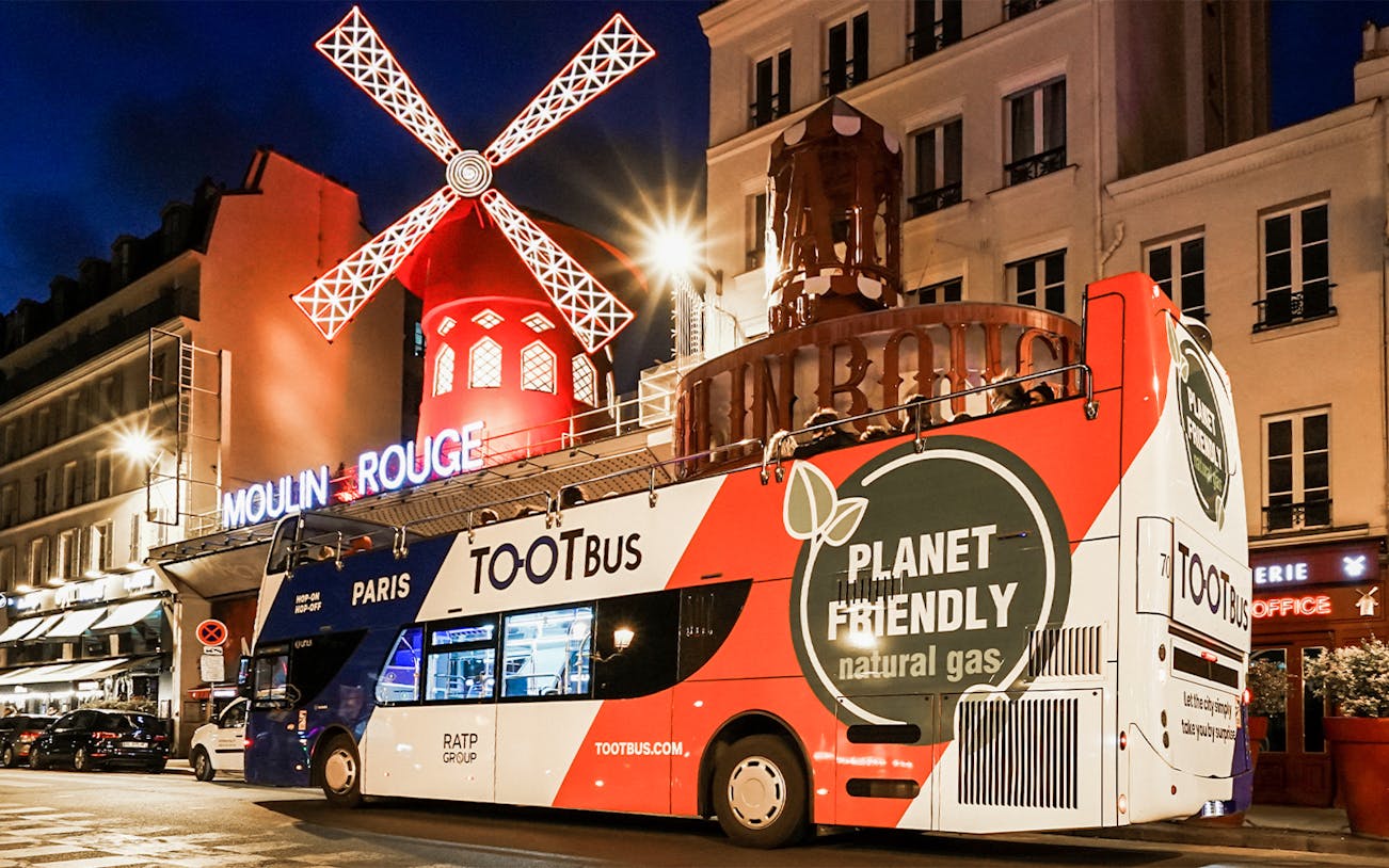 Tootbus in front of Moulin Rouge at night, Paris hop-on-hop-off tour.