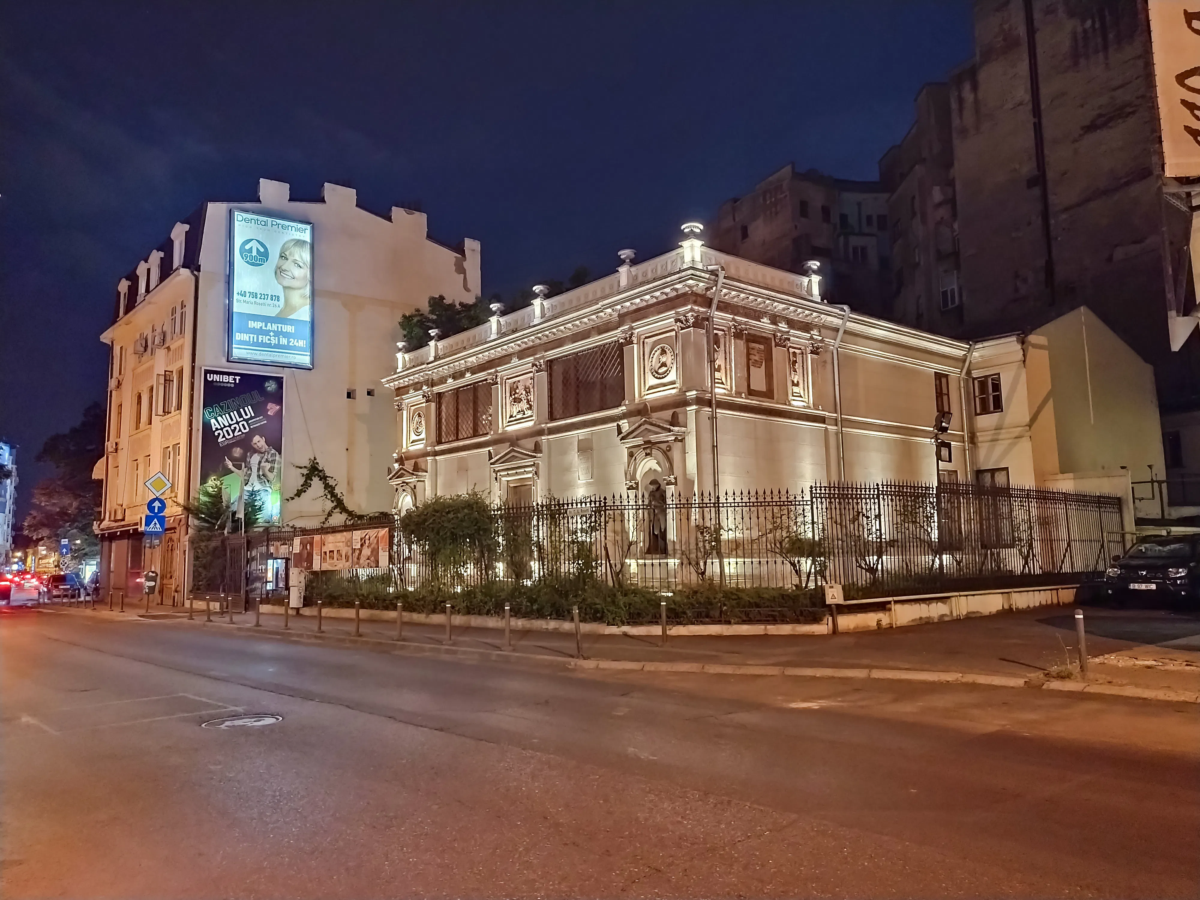 Historic building illuminated at night on a street in Bucharest, Romania.