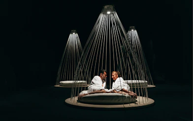 Couple relaxing in robes at QC Terme Milano Resort & Spa under modern lighting.