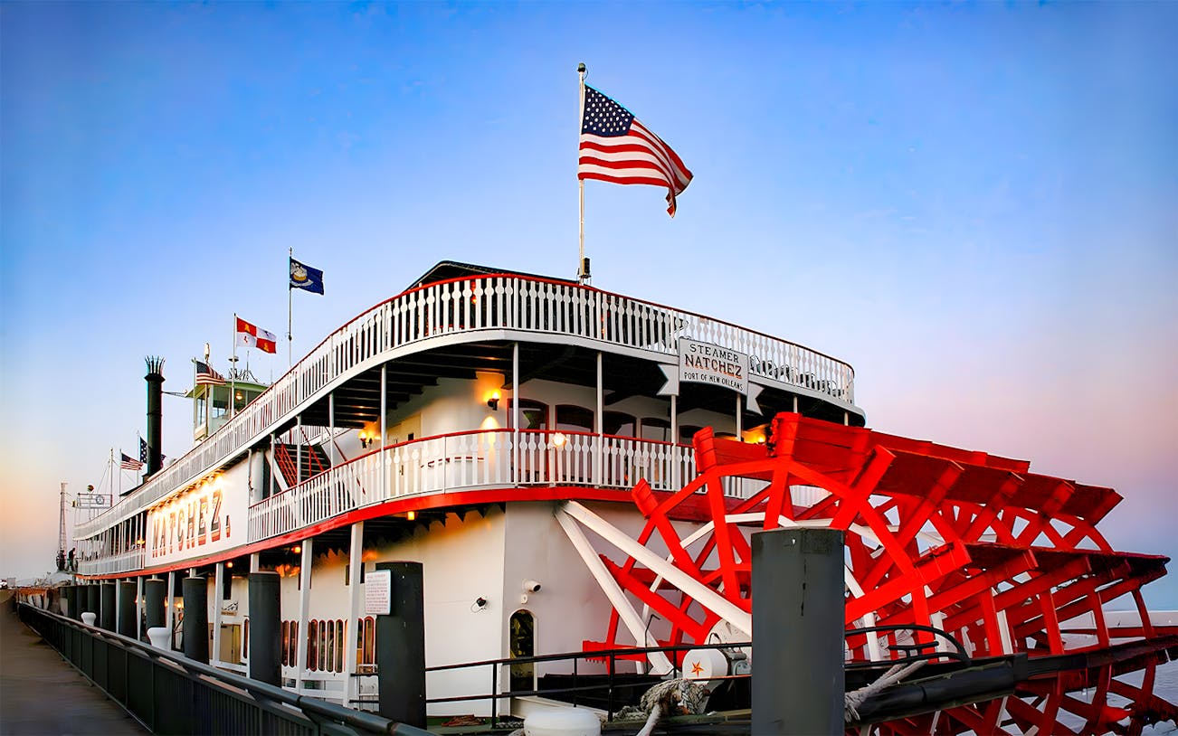 Steamboat Natchez docked in New Orleans, ready for evening dinner cruise boarding.